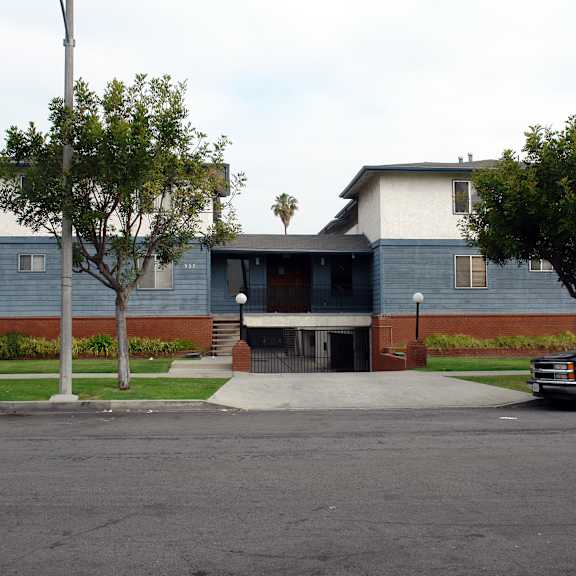 a black truck is parked on the street in front of a blue building.