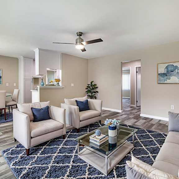 a living room with a grey couch, a coffee table, and a painting on the wall.