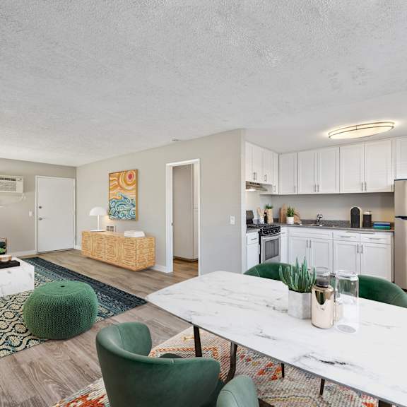 a modern kitchen with a white table and green chairs.