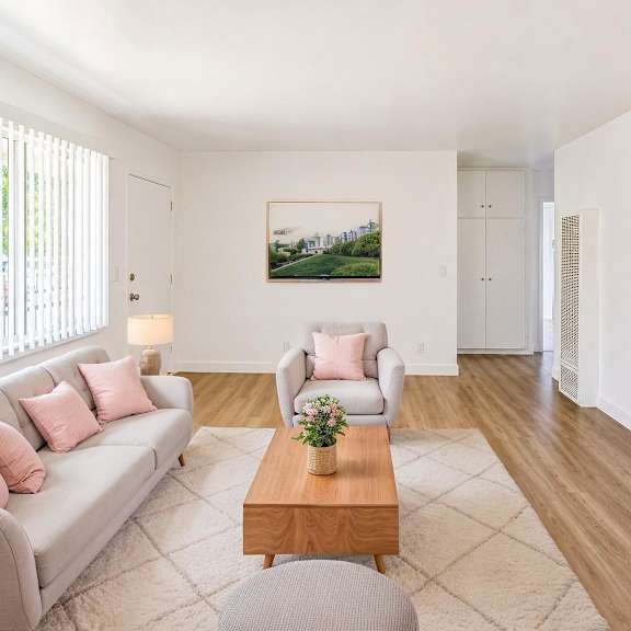 a living room with a grey couch, a coffee table, and a painting on the wall.