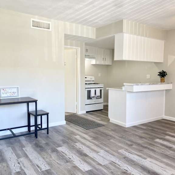 an empty living room with a kitchen in the background at south pointe apts, covina california