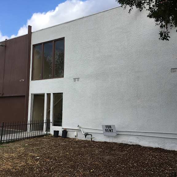 a white building with a brown door and windows.