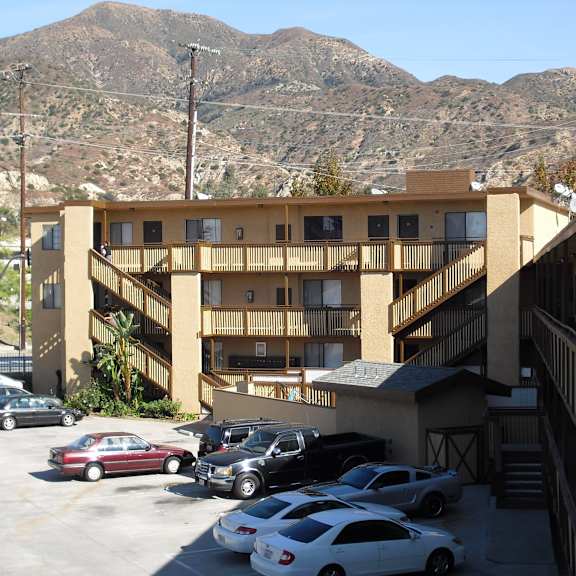 a parking lot with cars and a mountain in the background.
