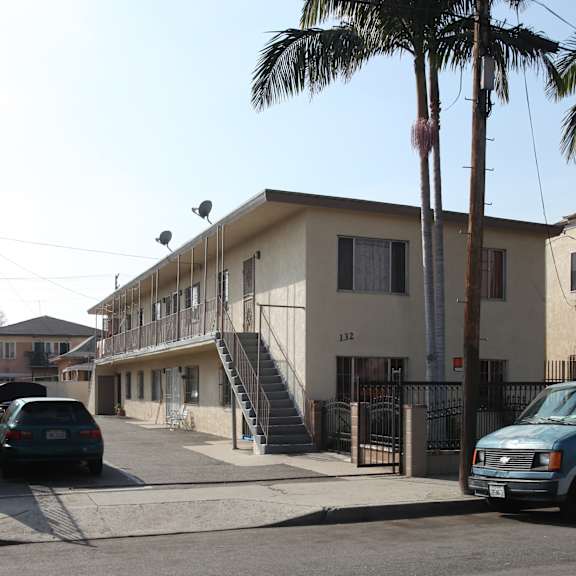 a street view of a residential area with a building numbered 132.