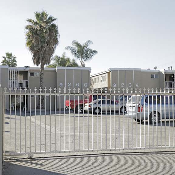a gate with the numbers 92609254 on it blocks the view of a parking lot.
