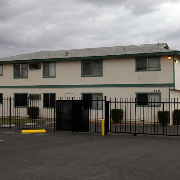 a white building with a black fence in front.