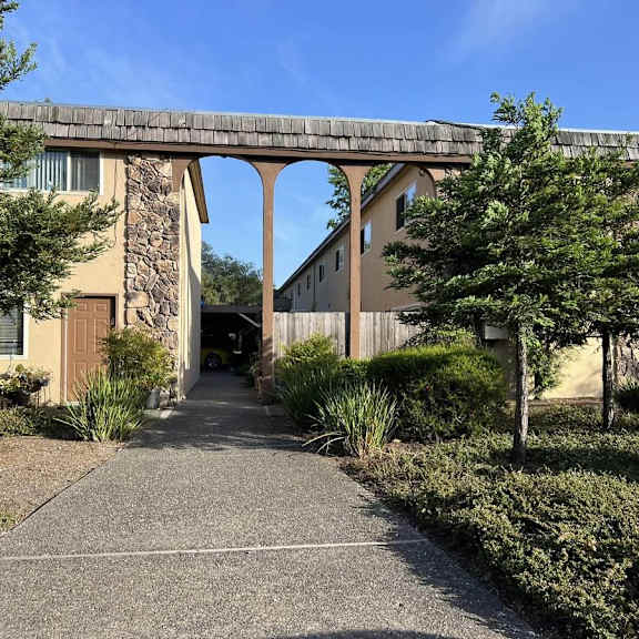 a stone building with a bridge-like structure above the entrance.