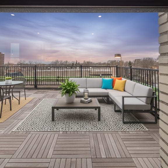 a balcony with a table, chairs, and a potted plant.