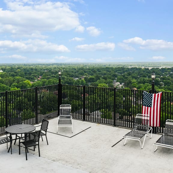 a patio with a table and chairs and an flag on a fence