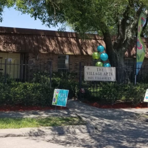a house with balloons and a sign in front of it