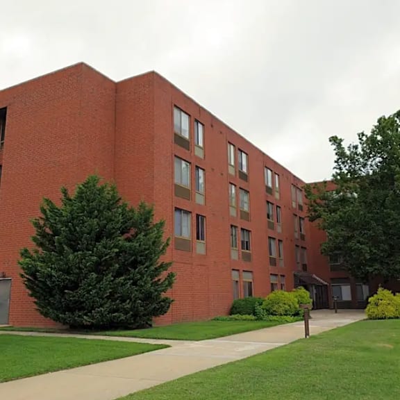 a red brick building with a green lawn in front.