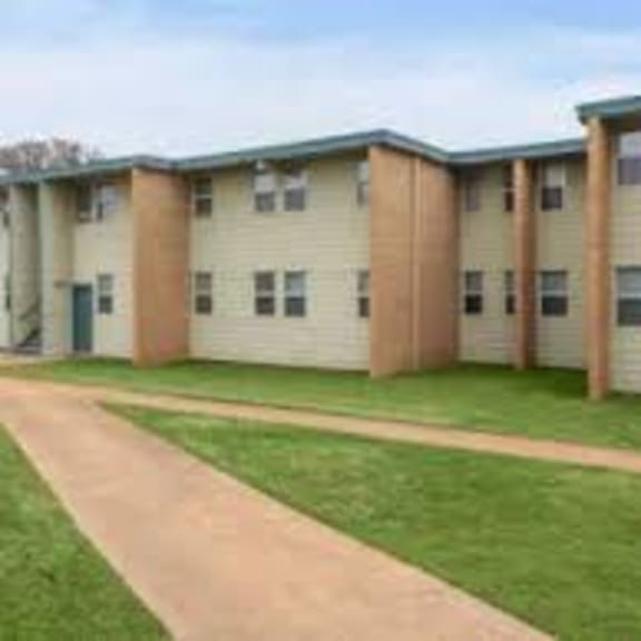an image of a row of apartment buildings with green grass