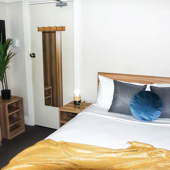 a bedroom with a white bed and a blue pillow
