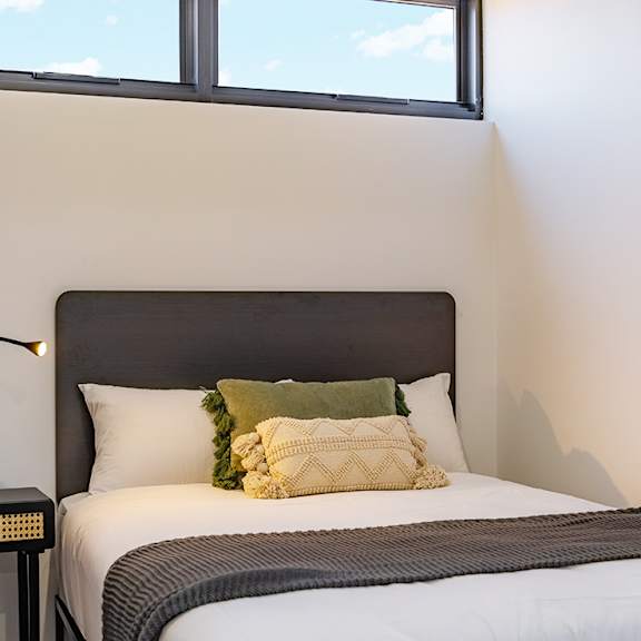 a small bedroom with a bed and a window