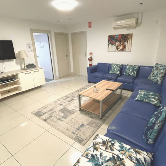 a living room with a blue couch and a tv