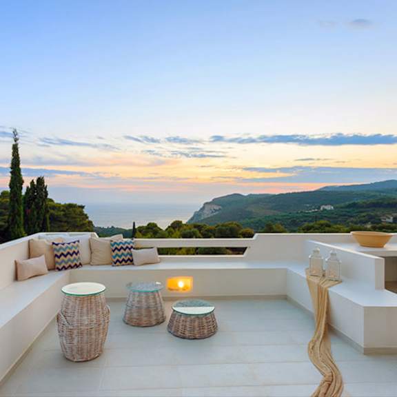 a patio with a table and chairs overlooking a scenic view.