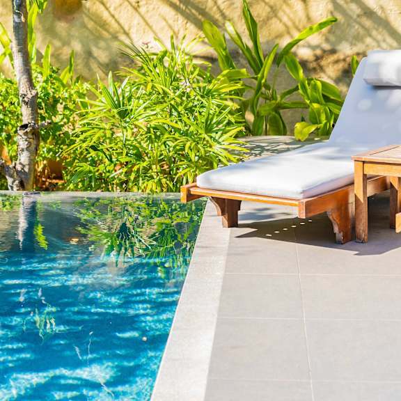 a pool with a chair and table by it.