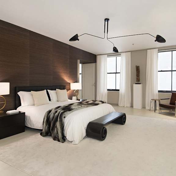 a modern bedroom with a large bed and a chair.