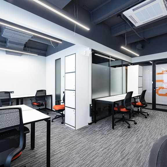 a modern office space with black chairs and white desks.