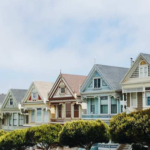 a row of victorian style houses with green shutters.
