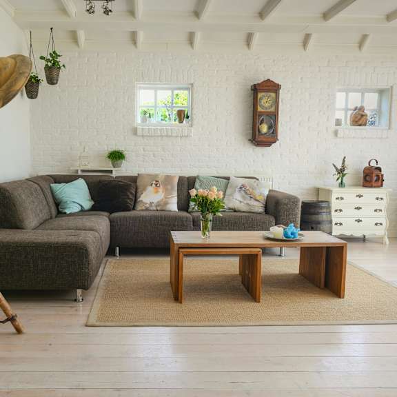 a living room with a grey couch, a wooden coffee table, and a white chair.