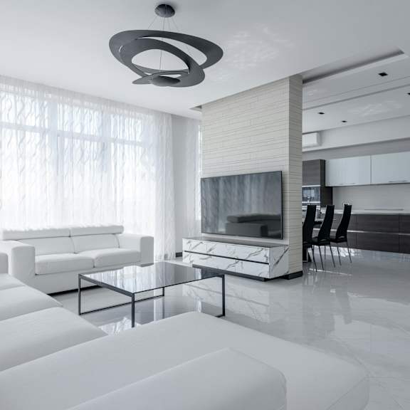 a modern living room with white furniture and a large window.