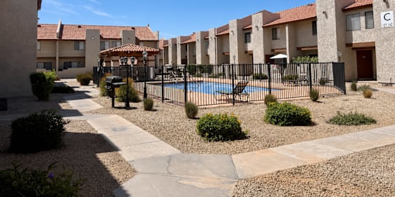 A row of houses with a pool in the foreground.