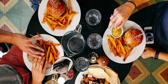A top view of a group of people sharing a meal with burgers and fries.at 901 Rendon, Texas, 76028
