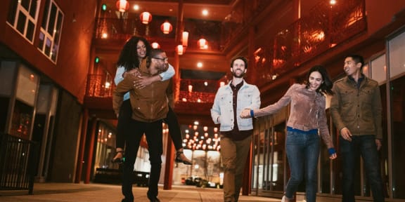 a group of people walking down a city street at night
