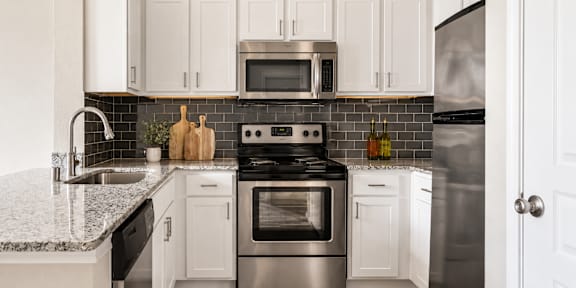A kitchen with white cabinets and a black stove top.