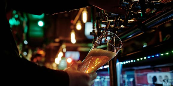 a beer being poured into a glass in a bar