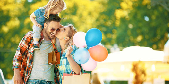 a man and woman with a little girl holding balloons and a bag at AGAVE APARTMENTS, California, 95757
