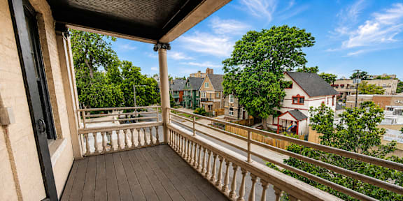 A balcony with a railing overlooks a residential area.