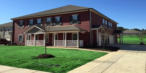 a red house with a yard and a sidewalk
