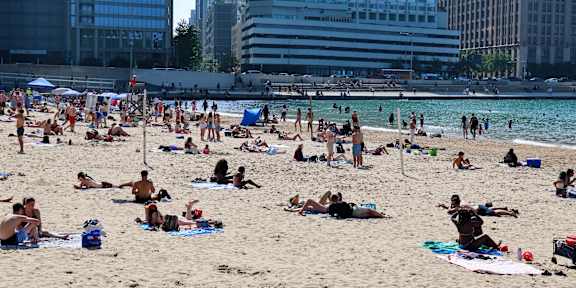 A crowded beach with people sunbathing and relaxing.