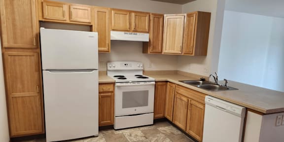 A kitchen with a white refrigerator, white oven, and white dishwasher.