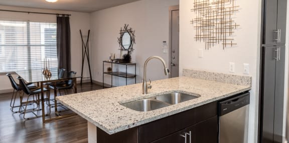 an open kitchen and living room with a large window and a sink