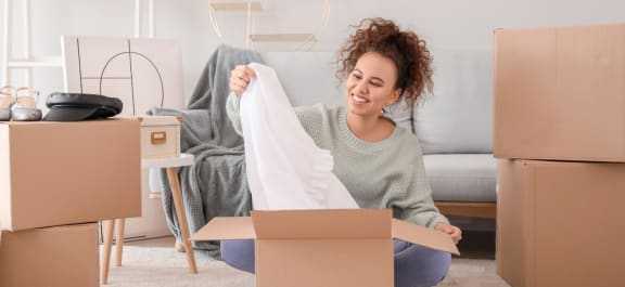 a woman sitting on the floor holding a pillow in a box