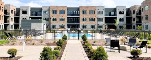 an exterior view of an apartment building with a pool