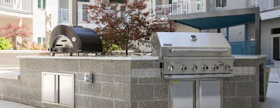 A modern outdoor kitchen with a grill and sink.