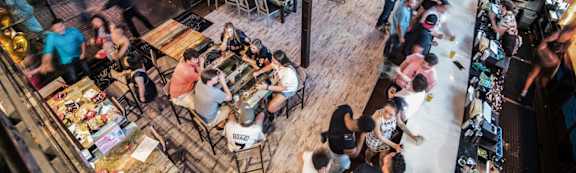 A busy restaurant with people eating and drinking.