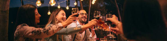 a group of people sitting around a table drinking wine