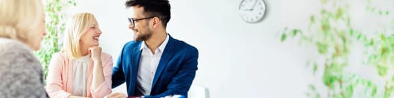 a man and a woman sitting at a table talking to each other