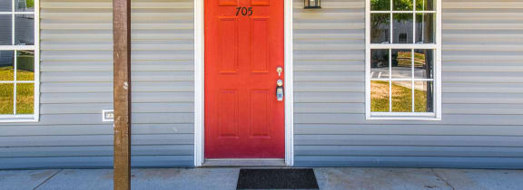 a red door on the side of a house at Ashford Place Apartments, North Carolina, 28081