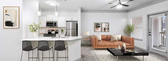 A modern living room with a kitchen area in the background.
