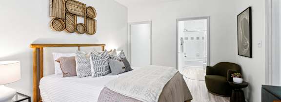 A bedroom with a bed, a chair, and a ceiling fan.