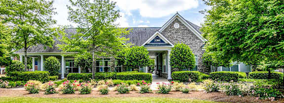 A house with a well-maintained lawn and garden in front.