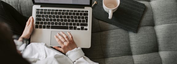 a person sitting on a couch using a laptop computer