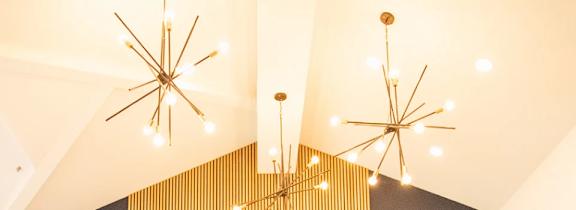 A large chandelier hangs from the ceiling in a white room.