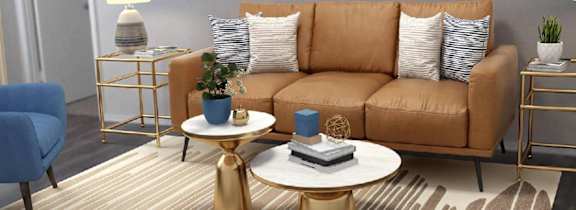 A living room with a blue chair, a brown couch, and a white coffee table.
